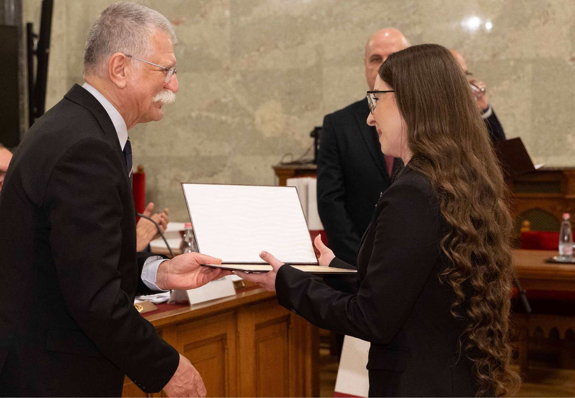 A képen a KRE ÁJK elsőéves joghallgatója látható, Sztrein Daniella Sztella, ahogy éppen kezet fog Kövér Lászlóval az Országgyűlés elnökével.